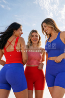 Three women wearing colorful  new AJ Activewear pieces in Red, blue Polka Dot and Red Gingham pattern with 'All-American Active Collection' text against a blue sky.