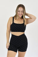 Model wearing Layered Sports Bra with black and white micro polka dot outer layer and solid black under layer.
