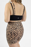 Model wearing Layered Sports Bra back view black base with black and leopard skinny straps.