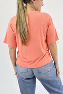 Model wearing Everyday Tee in Coral color. Back view.