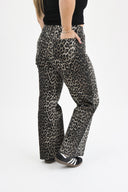 Back angled shot of model wearing RFM tummy control wide leg jeans in leopard wash