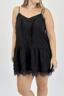 Black lace-trimmed dress worn by a model on a white background