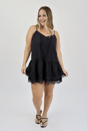 Woman wearing a black dress with lace trim on a white background