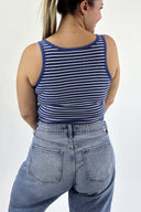 Model wearing The Striped Micro Ribbed Tank in navy base with white stripes. Back view.