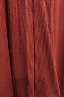 Closeup of ribbed material in rust color.
