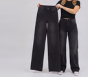 Women wearing a cut to length 40" original inseam black wide leg while holding a 40" inseam jean in her hands to show how long they are.