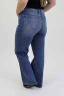Model wearing Wide Leg Tummy Control Jeans in a medium wash with rhinestones down the side seam. (back view)