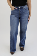 Model wearing Wide Leg Tummy Control Jeans in a medium wash with rhinestones down the side seam.