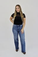 Model wearing Wide Leg Tummy Control Jeans in a medium wash with rhinestones down the side seam.