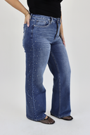 Model wearing Wide Leg Tummy Control Jeans in a medium wash with rhinestones down the side seam.